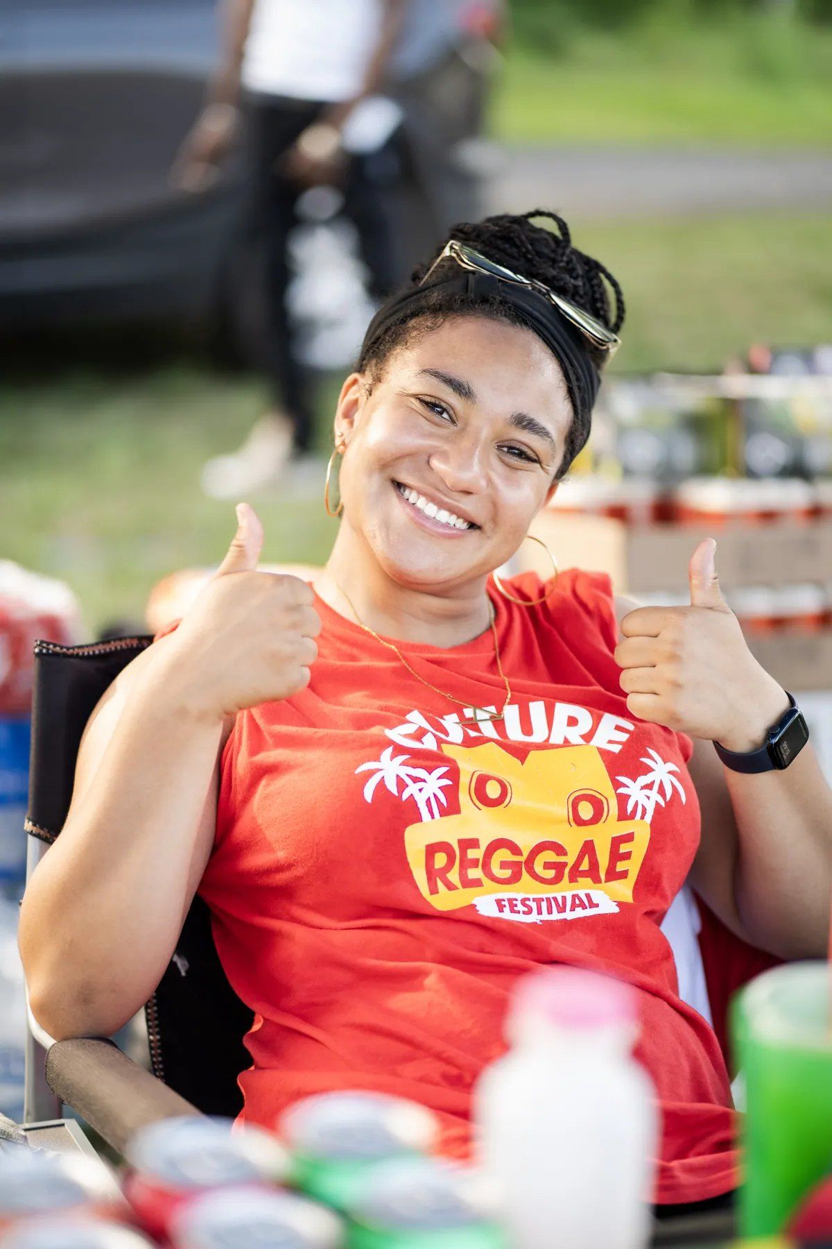 A smiling festival-goer in a red Culture Reggae Festival T-shirt giving two thumbs up, 2024