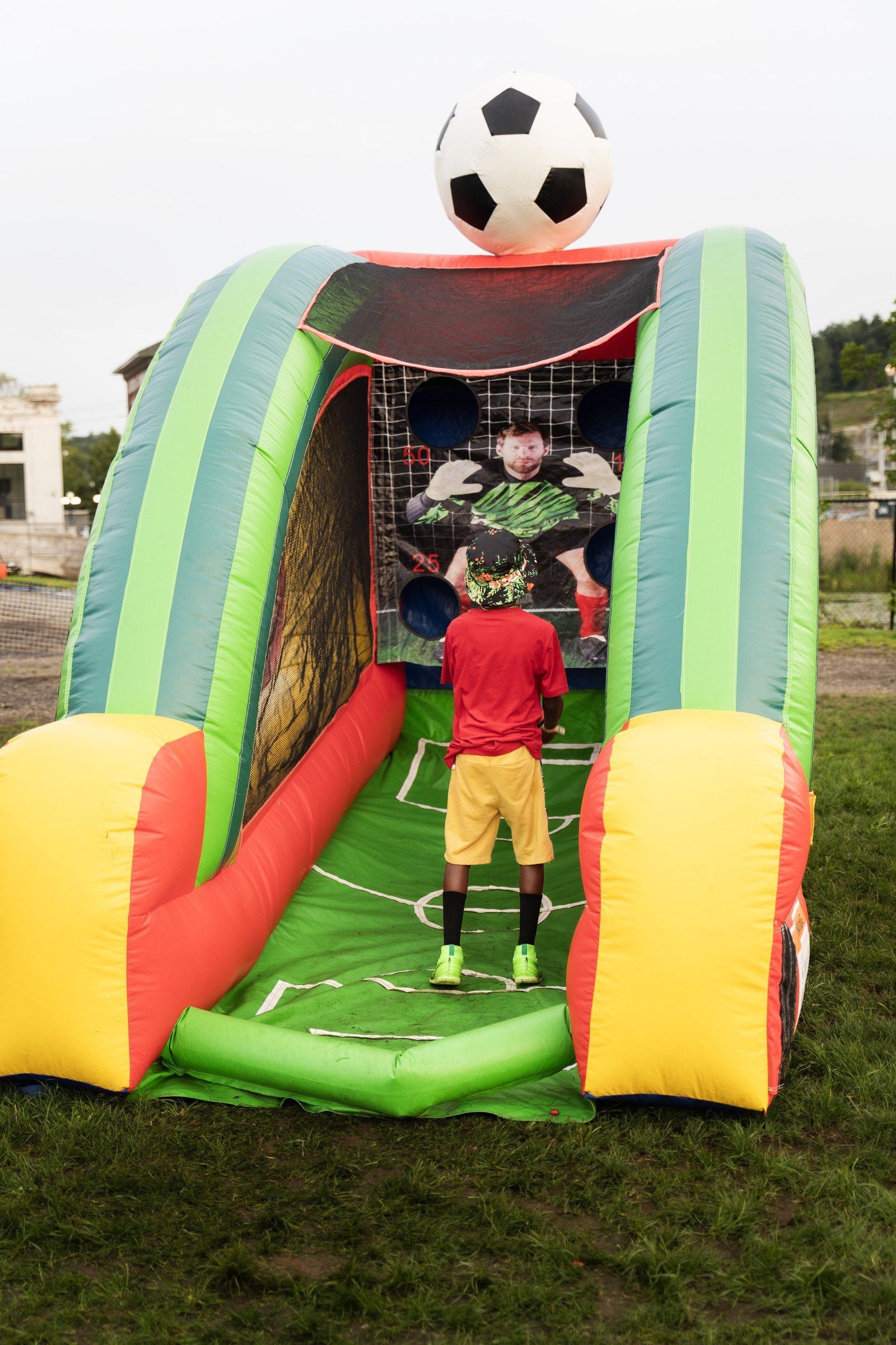 A child playing in the inflatable soccer game in the kids area, 2024